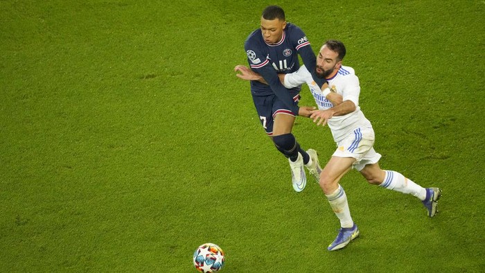 PSGs Kylian Mbappe, left, fights for the ball with Real Madrids Dani Carvajal during the Champions League, round of 16, first leg soccer match between Paris Saint Germain and Real Madrid at the Parc des Princes stadium, in Paris, France, Tuesday, Feb. 15, 2022. (AP Photo/Francois Mori)