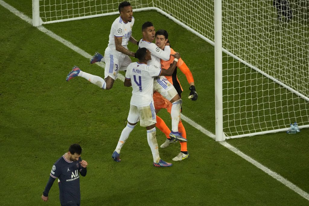 Real Madrid's goalkeeper Thibaut Courtois, right, celebrates with his teammates after he saves a penalty shot by PSG's Lionel Messi, bottom, during the Champions League, round of 16, first leg soccer match between Paris Saint Germain and Real Madrid at the Parc des Princes stadium, in Paris, France, Tuesday, Feb. 15, 2022. (AP Photo/Francois Mori)