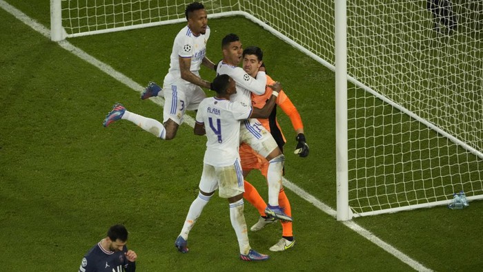 Real Madrids goalkeeper Thibaut Courtois, right, celebrates with his teammates after he saves a penalty shot by PSGs Lionel Messi, bottom, during the Champions League, round of 16, first leg soccer match between Paris Saint Germain and Real Madrid at the Parc des Princes stadium, in Paris, France, Tuesday, Feb. 15, 2022. (AP Photo/Francois Mori)