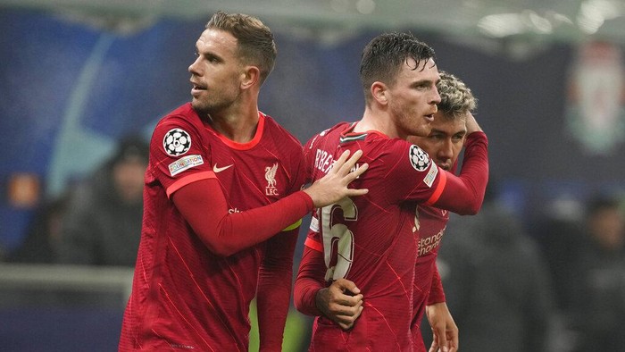 Liverpools Roberto Firmino, right, celebrates with his teammates Liverpools Jordan Henderson, left, and Liverpools Andrew Robertson after scoring his sides opening goal during the Champions League, round of 16, first leg soccer match between Inter Milan and Liverpool at the San Siro stadium in Milan, Italy, Wednesday, Feb. 16, 2022. (AP Photo/Antonio Calanni)