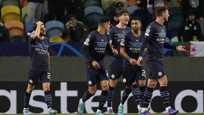 Manchester City players celebrate their fourth goal during the Champions League round of 16 soccer match between Sporting CP and Manchester City at the Alvalade stadium in Lisbon, Portugal, Tuesday, Feb. 15, 2022. (AP Photo/Armando Franca)