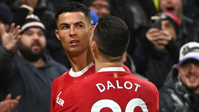 MANCHESTER, ENGLAND - FEBRUARY 15: Cristiano Ronaldo celebrates with teammate Diogo Dalot of Manchester United after scoring their teams first goal during the Premier League match between Manchester United and Brighton & Hove Albion at Old Trafford on February 15, 2022 in Manchester, England. (Photo by Gareth Copley/Getty Images)