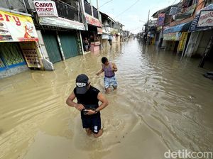Potret Warga Bekasi Beraktivitas di Tengah Banjir