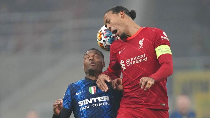 Liverpools Virgil van Dijk, right, heads the ball past Inter Milans Denzel Dumfries during the Champions League, round of 16, first leg soccer match between Inter Milan and Liverpool at the San Siro stadium in Milan, Italy, Wednesday, Feb. 16, 2022. (AP Photo/Antonio Calanni)