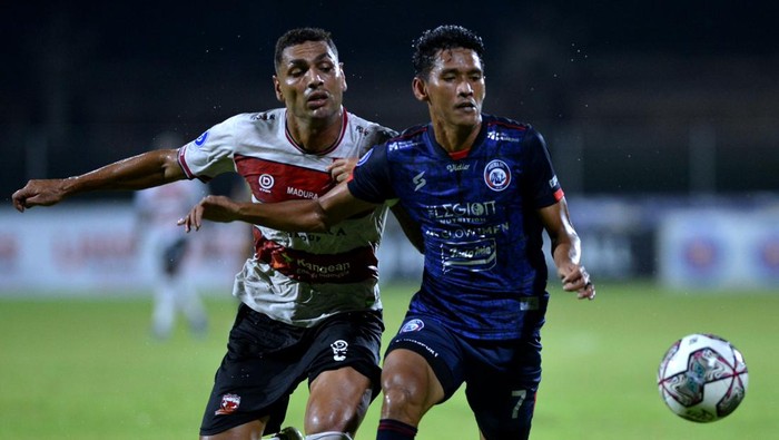 Pesepak bola Arema FC Ryan Kurnia (kanan) berebut bola dengan pesepak bola Madura United Jaimerson Da Silva Xavier (kiri) saat pertandingan Liga 1 di Stadion I Gusti Ngurah Rai, Denpasar, Bali, Jumat (18/2/2022). ANTARA FOTO/Fikri Yusuf/rwa.