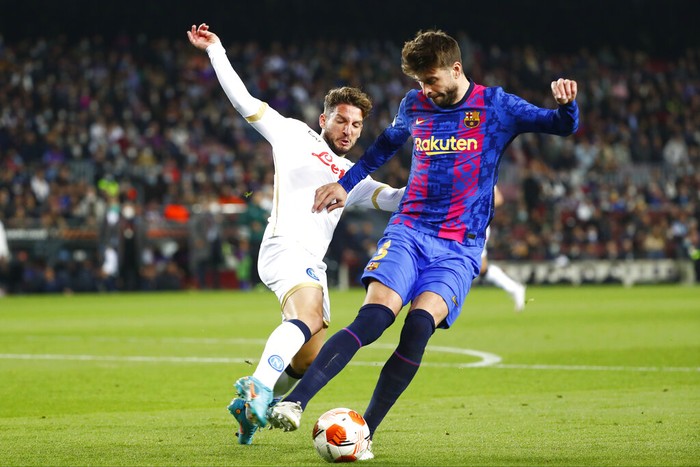 Napolis Dries Mertens, left, and Barcelonas Gerard Pique vie for the ball during the Europa League soccer match between Barcelona and Napoli in Barcelona, Spain, Thursday, Feb. 17, 2022. (AP Photo/Joan Monfort)