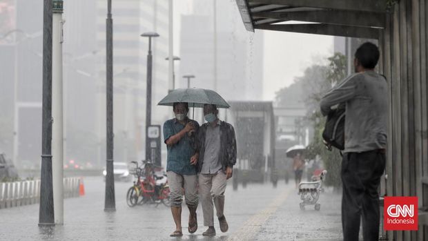 Sejumlah kendaraan dan warga melintas saat hujan di Bundaran HI, Jakarta, Jumat, 18 Februari 2022. Badan Meteorologi Klimatologi dan Geofisika (BMKG) memprediksi cuaca Jakarta hari ini, Jumat (18/2/2022) mayoritas  akan diguyur hujan dengan disertai petir dan angin kencang, sebagaimana dilansir dari laman resmi BMKG.go.id. BMKG menyebut potensi tersebut diprediksi terjadi pada siang hingga menjelang malam hari meliputi beberapa wilayah Jakarta. (CNN Indonesia/ Adhi Wicaksono)