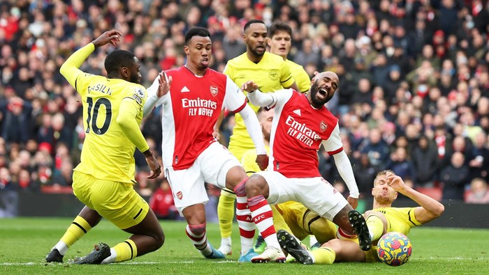 LONDON, ENGLAND - FEBRUARY 19: Alexandre Lacazette of Arsenal is challenged by Kristoffer Ajer of Brentford during the Premier League match between Arsenal and Brentford at Emirates Stadium on February 19, 2022 in London, England. (Photo by Mark Thompson/Getty Images)