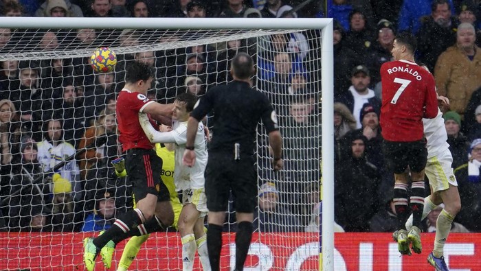 Manchester Uniteds Harry Maguire, left, scores his sides opening goal during the English Premier League soccer match between Leeds United and Manchester United, at Elland Road Stadium in Leeds, England, Sunday, Feb. 20, 2022. (AP Photo/Jon Super)