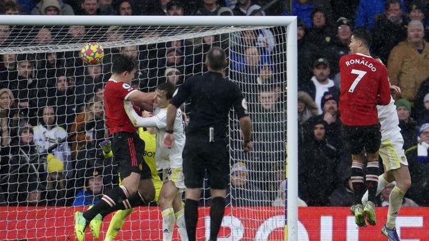 Manchester United's Harry Maguire, left, scores his side's opening goal during the English Premier League soccer match between Leeds United and Manchester United, at Elland Road Stadium in Leeds, England, Sunday, Feb. 20, 2022. (AP Photo/Jon Super)