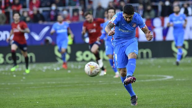 Atletico Madrid's Luis Suarez fires a shot during the Spanish La Liga soccer match between Osasuna and Atletico de Madrid, at El Sadar stadium, in Pamplona, northern Spain, Saturday, Feb.19, 2022. (AP Photo/Alvaro Barrientos)