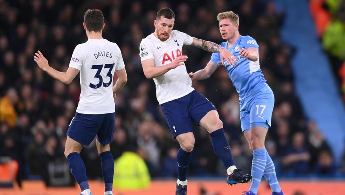 MANCHESTER, ENGLAND - FEBRUARY 19: Pierre-Emile Hojbjerg of Tottenham Hotspur is brought down by Kevin De Bruyne of Manchester City during the Premier League match between Manchester City and Tottenham Hotspur at Etihad Stadium on February 19, 2022 in Manchester, England. (Photo by Laurence Griffiths/Getty Images)