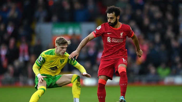 LIVERPOOL, ENGLAND - FEBRUARY 19: Mohamed Salah of Liverpool is challenged by Brandon Williams of Norwich City during the Premier League match between Liverpool and Norwich City at Anfield on February 19, 2022 in Liverpool, England. (Photo by Gareth Copley/Getty Images)