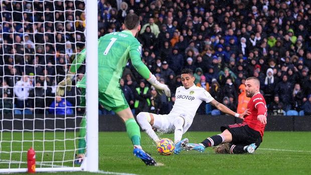 LEEDS, ENGLAND - FEBRUARY 20: Raphinha of Leeds United scores their side's second goal past David De Gea of Manchester United during the Premier League match between Leeds United and Manchester United at Elland Road on February 20, 2022 in Leeds, England. (Photo by Laurence Griffiths/Getty Images)