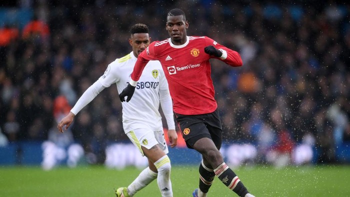 LEEDS, ENGLAND - FEBRUARY 20: Paul Pogba of Manchester United battles for possession with Junior Firpo of Leeds United during the Premier League match between Leeds United and Manchester United at Elland Road on February 20, 2022 in Leeds, England. (Photo by Laurence Griffiths/Getty Images)