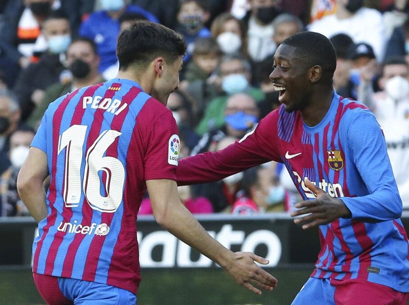 Barcelona's Pierre-Emerick Aubameyang, 2nd left, celebrates with team mates after scoring the opening goal during a Spanish La Liga soccer match between Valencia and Barcelona at the Mestalla stadium in Valencia, Spain, Sunday, Feb. 20, 2022. (AP Photo/Alberto Saiz)