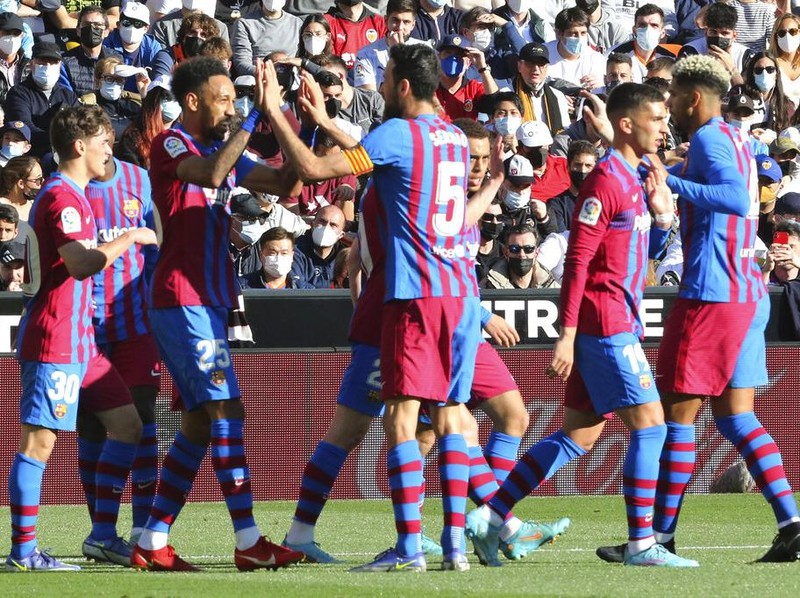 Barcelona's Pierre-Emerick Aubameyang, 2nd left, celebrates with team mates after scoring the opening goal during a Spanish La Liga soccer match between Valencia and Barcelona at the Mestalla stadium in Valencia, Spain, Sunday, Feb. 20, 2022. (AP Photo/Alberto Saiz)