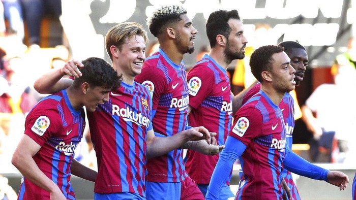 Barcelonas Frenkie de Jong, 2nd left, celebrates after scoring his sides second goal during a Spanish La Liga soccer match between Valencia and Barcelona at the Mestalla stadium in Valencia, Spain, Sunday, Feb. 20, 2022. (AP Photo/Alberto Saiz)