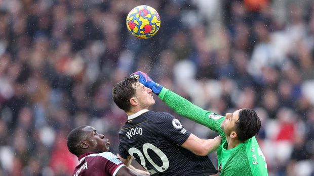LONDON, ENGLAND - FEBRUARY 19: Lukasz Fabianski of West Ham United jumps for the ball with Chris Wood of Newcastle United watched by Kurt Zouma of West Ham United during the Premier League match between West Ham United and Newcastle United at London Stadium on February 19, 2022 in London, England. (Photo by Warren Little/Getty Images)