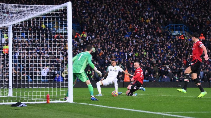 LEEDS, ENGLAND - FEBRUARY 20: Raphinha of Leeds United scores their sides second goal past David De Gea of Manchester United during the Premier League match between Leeds United and Manchester United at Elland Road on February 20, 2022 in Leeds, England. (Photo by Laurence Griffiths/Getty Images)