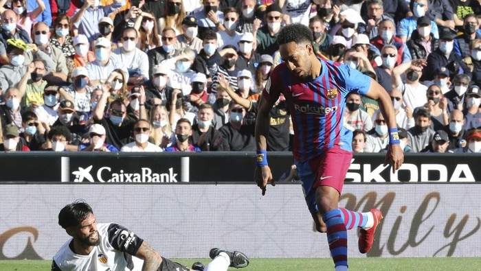Barcelonas Pierre-Emerick Aubameyang, right, reacts as he scores the opening goal during a Spanish La Liga soccer match between Valencia and Barcelona at the Mestalla stadium in Valencia, Spain, Sunday, Feb. 20, 2022. (AP Photo/Alberto Saiz)