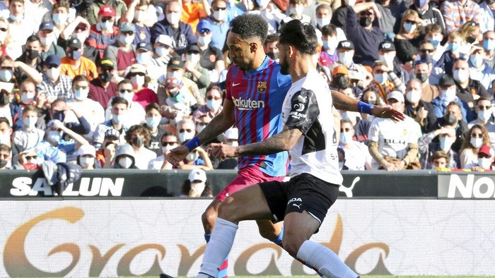 Barcelonas Pierre-Emerick Aubameyang, left, is challenged by Valencias Omar Alderete during a Spanish La Liga soccer match between Valencia and Barcelona at the Mestalla stadium in Valencia, Spain, Sunday, Feb. 20, 2022. (AP Photo/Alberto Saiz)