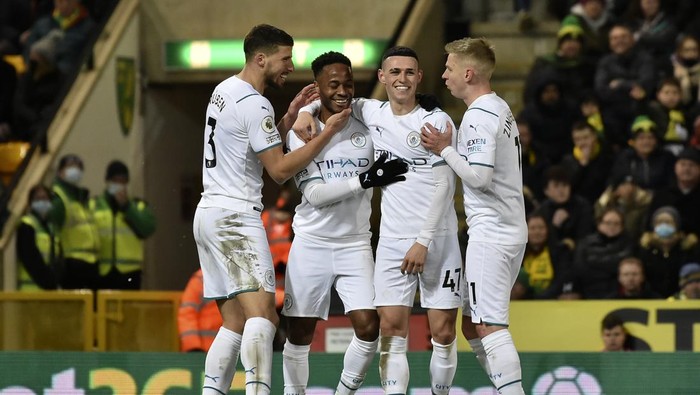 Manchester Citys Raheem Sterling, second left, celebrates with teammates after scoring his sides third goal during the English Premier League soccer match between Norwich City and Manchester City at Carrow Road Stadium in Norwich, England, Saturday, Feb. 12, 2022. (AP Photo/Rui Vieira)