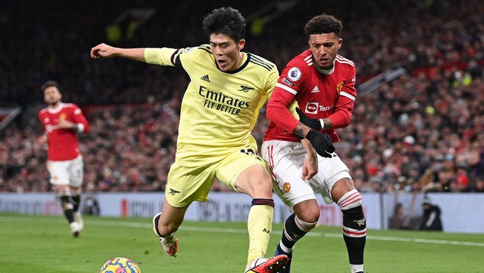 MANCHESTER, ENGLAND - DECEMBER 02:  Takehiro Tomiyasu of Arsenal is challenged by Jadon Sancho of Manchester United during the Premier League match between Manchester United  and  Arsenal at Old Trafford on December 02, 2021 in Manchester, England. (Photo by Shaun Botterill/Getty Images)