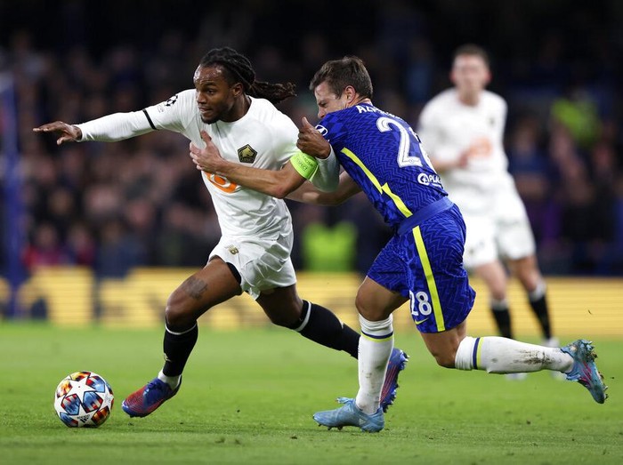 Lille's Sven Botman, right, vies for the ball with Chelsea's Hakim Ziyech, center, during the Champions League round of 16, first leg, soccer match between Chelsea and LOSC Lille at Stamford Bridge stadium in London, Tuesday, Feb. 22, 2022. (AP Photo/Ian Walton)