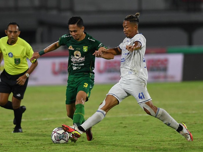 Pesepak bola Persebaya Reva Adi Utama (tengah) berebut bola dengan pemain Arema FC Dendi Santoso dalam pertandingan sepak bola Liga 1 di Stadion I Wayan Dipta, Gianyar, Bali, Rabu (23/2/2022). ANTARA FOTO/Nyoman Budhiana/rwa.