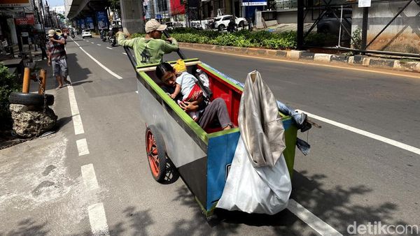 Mencari Rezeki Sambil Gendong Anak di Jalanan Jakarta
