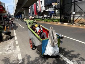 Mencari Rezeki Sambil Gendong Anak di Jalanan Jakarta
