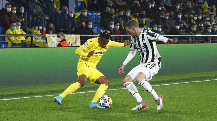 Juventus Dusan Vlahovic, right, is challenged by Villarreals Etienne Capoue, second right, and Villarreals Pau Torres during the Champions League, round of 16, first leg soccer match between Villarreal and Juventus at the Ceramica stadium in Villarreal, in Villarreal, Spain, Tuesday, Feb. 22, 2022. (AP Photo/Alberto Saiz)
