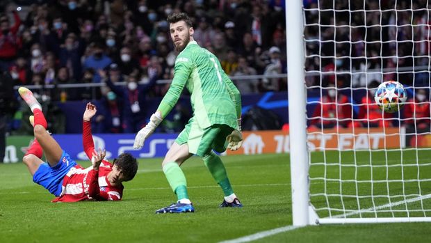 Atletico Madrid's Joao Felix, left, scores the opening goal of his team as Manchester United's goalkeeper David de Gea looks the ball during the Champions League, round of 16, first leg soccer match between Atletico Madrid and Manchester United at the Wanda Metropolitano stadium in Madrid, Spain, Wednesday, Feb. 23, 2022. (AP Photo/Manu Fernandez)