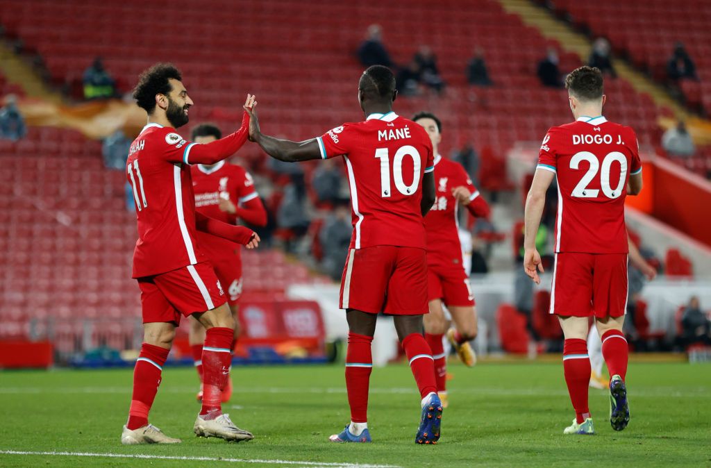 NORWICH, ENGLAND - AUGUST 14: Diogo Jota of Liverpool celebrates with teammates Mohamed Salah and Sadio Mane after scoring their side's first goal during the Premier League match between Norwich City and Liverpool at Carrow Road on August 14, 2021 in Norwich, England. (Photo by Marc Atkins/Getty Images)