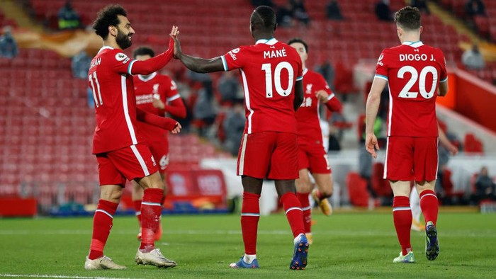 NORWICH, ENGLAND - AUGUST 14: Diogo Jota of Liverpool celebrates with teammates Mohamed Salah and Sadio Mane after scoring their sides first goal during the Premier League match between Norwich City and Liverpool at Carrow Road on August 14, 2021 in Norwich, England. (Photo by Marc Atkins/Getty Images)