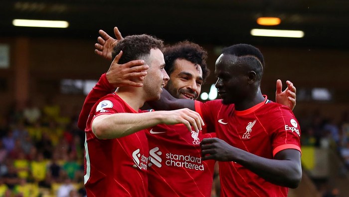 NORWICH, ENGLAND - AUGUST 14: Diogo Jota of Liverpool celebrates with teammates Mohamed Salah and Sadio Mane after scoring their sides first goal during the Premier League match between Norwich City and Liverpool at Carrow Road on August 14, 2021 in Norwich, England. (Photo by Marc Atkins/Getty Images)