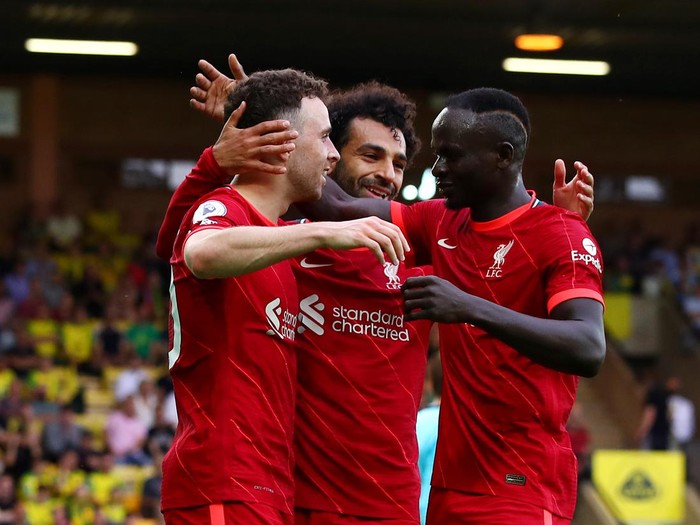 NORWICH, ENGLAND - AUGUST 14: Diogo Jota of Liverpool celebrates with teammates Mohamed Salah and Sadio Mane after scoring their sides first goal during the Premier League match between Norwich City and Liverpool at Carrow Road on August 14, 2021 in Norwich, England. (Photo by Marc Atkins/Getty Images)