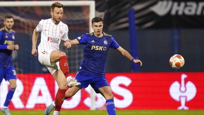 Sevillas Ivan Rakitic, left, is challenged by Dinamo Zagrebs Amer Gojak during the Europa League play-off second leg soccer match between Dinamo Zagreb and Sevilla at the Maksimir stadium in Zagreb, Croatia, Thursday, Feb. 24, 2022. (AP Photo/Darko Bandic)