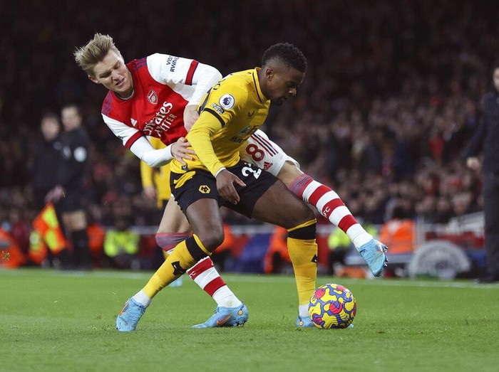 Wolverhampton Wanderers' Nelson Semedo, right, and Arsenal's Martin Odegaard vie for the ball during the English Premier League soccer match between Arsenal and Wolverhampton Wanderers at the Emirates Stadium, London, Thursday, Feb. 24, 2022. (AP Photo/Ian Walton)