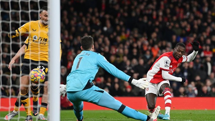 LONDON, ENGLAND - FEBRUARY 24: Nicolas Pepe of Arsenal scores their sides first goal past Jose Sa of Wolverhampton Wanderers during the Premier League match between Arsenal and Wolverhampton Wanderers at Emirates Stadium on February 24, 2022 in London, England. (Photo by Shaun Botterill/Getty Images)