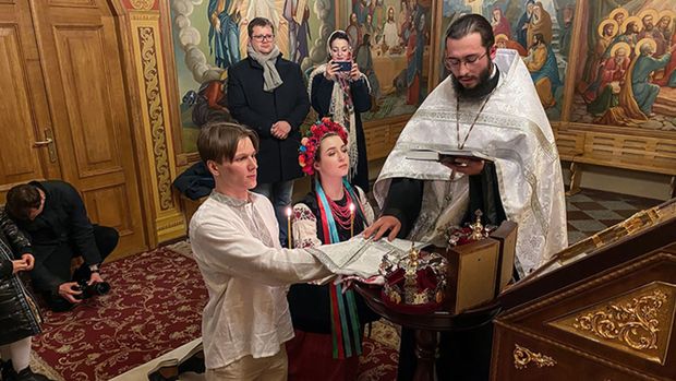 Sviatoslav Fursin, left, and Yaryna Arieva kneel during their wedding ceremony at St. Michael's cathedral in Kyiv on Thursday. (Christian Streib/CNN)