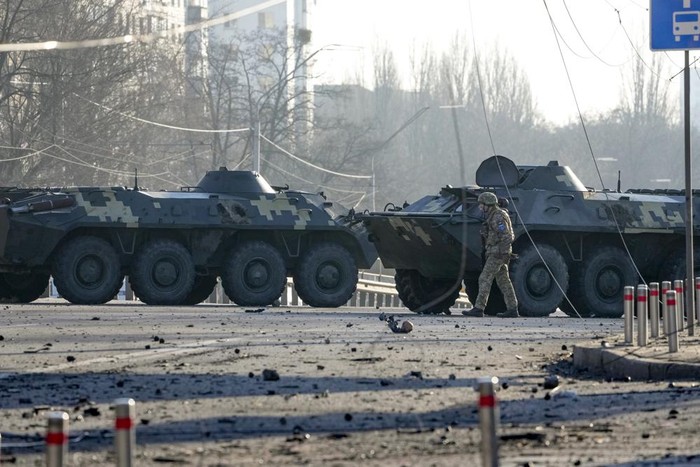 Kendaraan lapis baja miik Ukraina memblokir salah satu ruas jalanan di Kiev, Ukraina A soldier walks along Ukrainian armored vehicles blocking a street in Kyiv, Ukraine, Saturday, Feb. 26, 2022. Russian troops stormed toward Ukraine's capital Saturday, and street fighting broke out as city officials urged residents to take shelter. (AP Photo/Efrem Lukatsky)