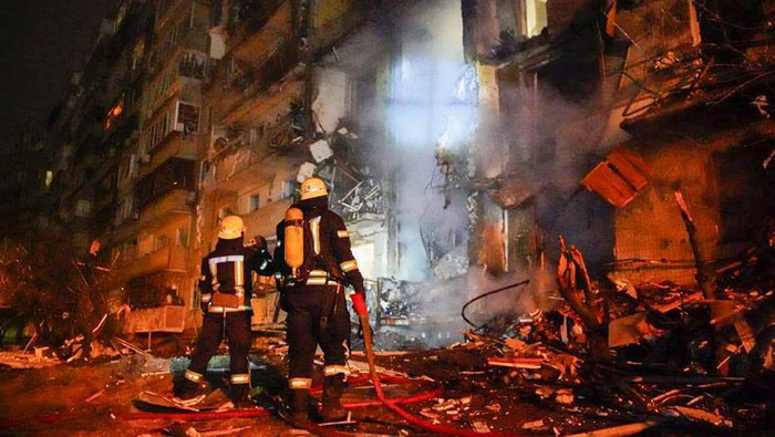 In this handout photo taken from video released by Ukrainian Police Department Press Service released on Friday, Feb. 25, 2022, firefighters inspect the damage at a building following a rocket attack on the city of Kyiv, Ukraine, Friday, Feb. 25, 2022. Russia is pressing its invasion of Ukraine to the outskirts of the capital. That comes a day after it unleashed airstrikes on cities and military bases and sent in troops and tanks from three sides. (Ukrainian Police Department Press Service via AP)
