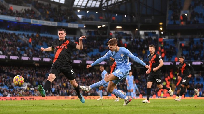 MANCHESTER, ENGLAND - NOVEMBER 21: James McAtee of Manchester City shoots whilst under pressure from Michael Keane of Everton during the Premier League match between Manchester City and Everton at Etihad Stadium on November 21, 2021 in Manchester, England. (Photo by Laurence Griffiths/Getty Images)