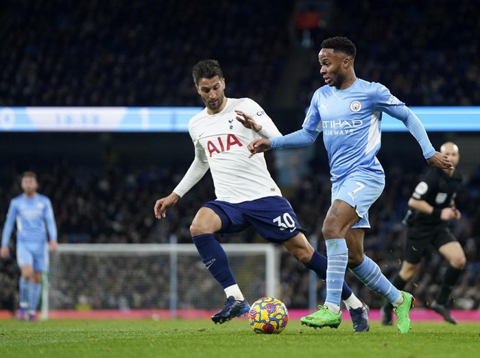 Manchester Citys Raheem Sterling, right, duels for the ball with Tottenhams Rodrigo Bentancur during the English Premier League soccer match between Manchester City and Tottenham Hotspur, at the Etihad stadium in Manchester, England, Saturday, Feb. 19, 2022. (AP Photo/Jon Super)