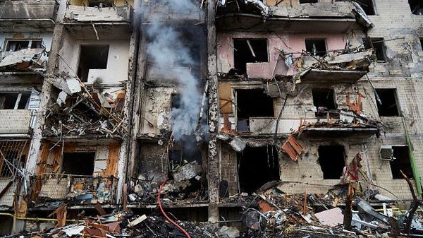 KYIV, UKRAINE - FEBRUARY 25: A boy plays on a swing in front of a damaged residential block hit by an early morning missile strike on February 25, 2022 in Kyiv, Ukraine. Yesterday, Russia began a large-scale attack on Ukraine, with Russian troops invading the country from the north, east and south, accompanied by air strikes and shelling. The Ukrainian president said that at least 137 Ukrainian soldiers were killed by the end of the first day. (Photo by Chris McGrath/Getty Images)