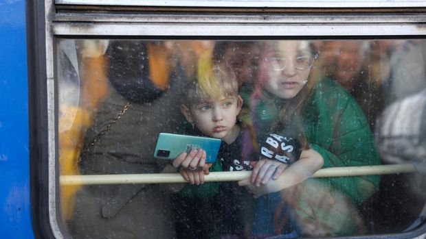 Ribuan Warga Ukraina Berdesakan di Stasiun Kiev untuk Mengungsi A woman and her son look out from an evacuation train from Kyiv to Lviv at Kyiv central train station, Ukraine, February 25, 2022. REUTERS/Umit Bektas TPX IMAGES OF THE DAY