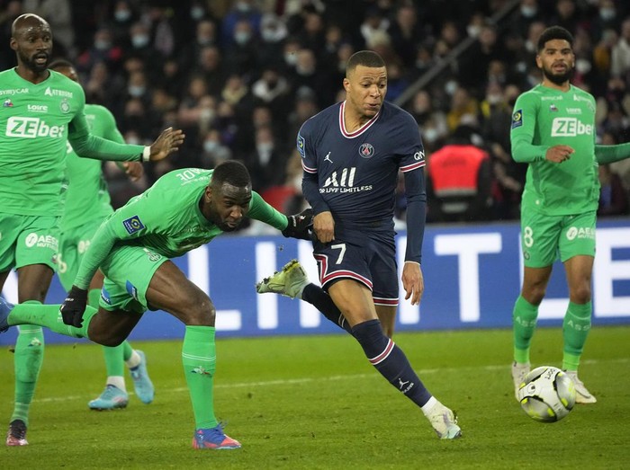 Saint-Etiennes Mickael Nade, left, and PSGs Kylian Mbappe challenge for the ball during the French League One soccer match between Paris Saint Germain and Saint-Etienne at the Parc des Princes stadium in Paris, Saturday, Feb. 26, 2022. (AP Photo/Michel Euler)