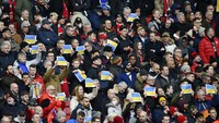 Para suporter Manchester United ramai-ramai membentangkan bendera Ukraina (AP)
